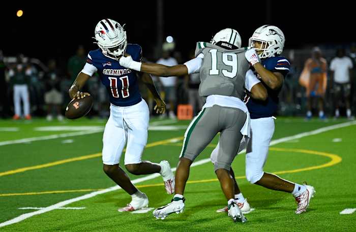 Chaminade-Madonna quarterback Cedrick Bailey (11) tries to avoid the pass rush of Miami Central's Deangelo Thompson (19).